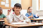 Girl scratching her head with pen