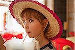 Girl Wearing Hat and Drinking from Straw