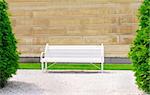 Empty wooden bench on the wall backgroundon a sunny day