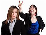 Professional woman holds rabbit ears gesture over a worker