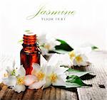 Essential oil with jasmine flower on wooden plank
