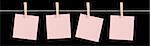 Four blank pink sticky notes held on a string by pegs isolated on a black background.