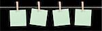 Four blank green sticky notes held on a string by pegs isolated on a black background.