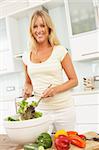 Woman Preparing Salad In Modern Kitchen