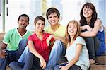 Group Of Teenage Friends Sitting On College Steps Outside