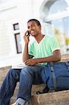 Male Teenage Student Sitting Outside On College Steps