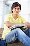 Male Teenage Student Sitting Outside On College Steps