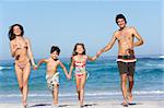 Young Family Running Along Beach on Holiday