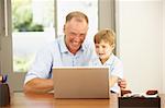 Father And Son Using Laptop At Home