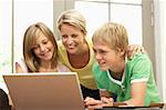 Mother And Teenage Children Using Laptop At Home