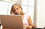 Worried Looking Teenage Girl Using Laptop At Home