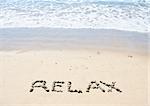 Relax written in sand at beach