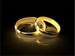 Two golden wedding rings isolated on black background.