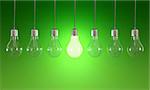 Seven light bulbs with lit one on green background