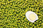 Directly above photograph of a half of an egg and green peas.