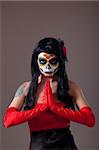 Praying woman with sugar skull make-up, the Day of the Dead