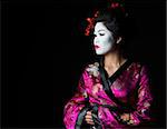Portrait of geisha looking on copy space isolated on black