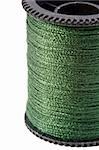 Close-up photograph of green thread spool on a white background.