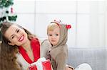 Happy young mother and baby spending Christmas time together