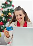 Happy young woman making Christmas shopping on internet