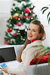 Happy young woman making online Christmas purchases