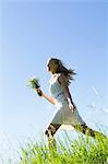 Woman carrying bouquet in tall grass