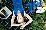 Smiling woman laying on blanket outdoors