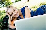 Smiling woman using laptop outdoors