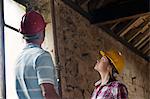 Construction workers examining pipe