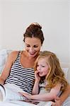 Mother and daughter reading in bed