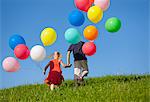 Enfants avec des ballons colorés dans l'herbe