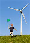 Boy with pinwheel by wind turbine