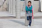 Frowning girl leaning against column