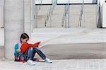 Girl reading folder outdoors