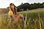 Woman sitting in grassy field