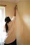 Woman painting trim with paintbrush
