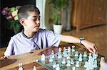 Boy playing chess in living room