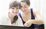 Teenage girls using laptop together