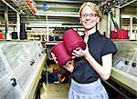 Worker with spools of thread in factory