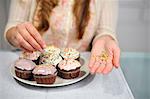 Woman putting garnish on muffins on plate