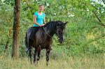 Smiling girl riding on horse