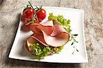 Open face sandwich with turkey ham and Lollo Bianco, thyme and cherry tomatoes