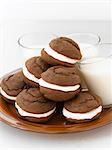 Teller mit Whoopie Pies mit drei Gläser Milch