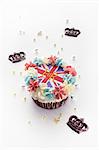 Un petit gâteau garni de crème au beurre et un Union Jack entouré de couronnes au chocolat