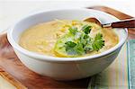 A Bowl of Creamy Squash and Corn Soup with Tomatillo and Cilantro Garnish