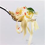 Tagliatelle, chilli, basil and grated Parmesan on a fork