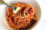 Spaghetti with tomato sauce on a plate and on a fork