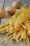 Tagliatelle and eggs on a wooden surface