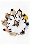 Group of people in a circle with woman in the middle, high angle view