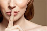 Woman with finger on lips, close up